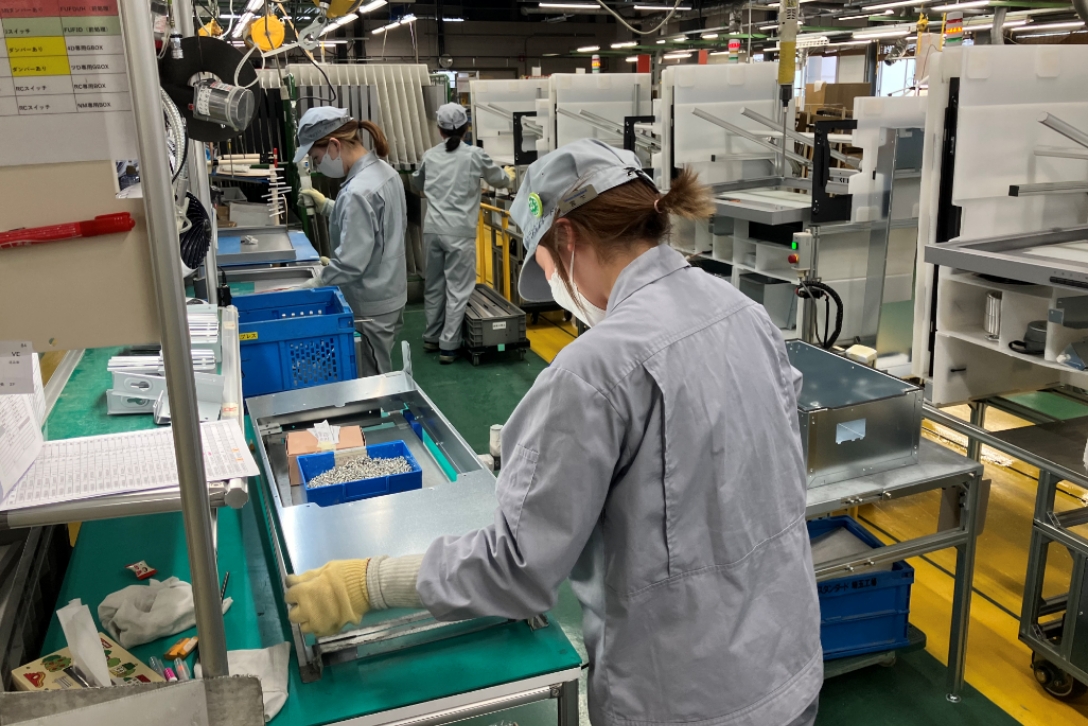 組立職場では、部品を電動ドライバーで取り付けています。